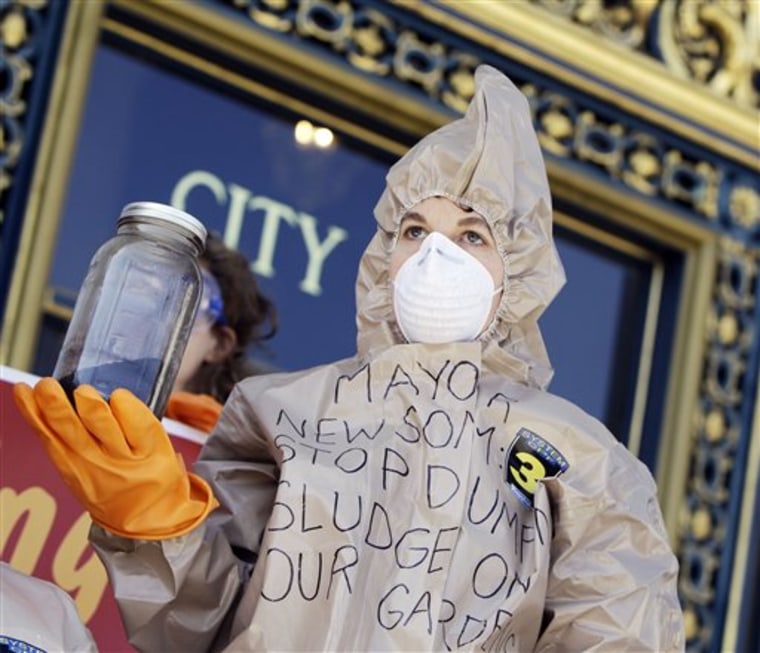 A demonstrator with the Organic Consumers Association hold a jar of city-issued compost on the steps of city hall  in San Francisco,  Thursday, March 4, 2010. Protesters held the event to speak out against what they believe is contaminated compost issued by the city for use in residents' gardens.  (AP Photo/Marcio Sanchez)